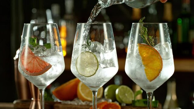 Super slow motion of preparing gin and tonic drinks with speed motion. Filmed on high speed cinema camera, 1000 fps, placed on high speed cine bot. Bar with bottles on background.