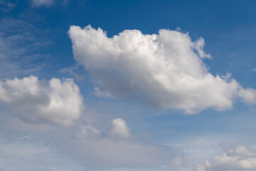 White cumulus clouds on a clear blue sky.