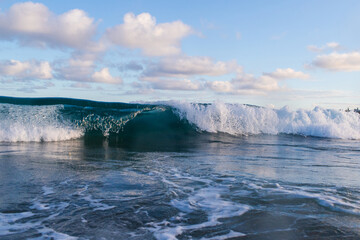Fototapeta na wymiar Wave barrel braking on the beach shore.