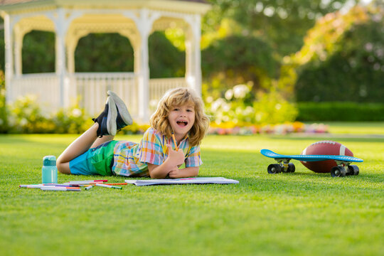 Child learning outside in the nature park. Relaxation and childhood concept. Little boy with brush paint painting. Kid artist painter draw pictures oudoor.