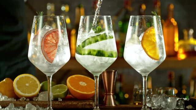 Super slow motion of preparing gin and tonic drinks with speed motion. Filmed on high speed cinema camera, 1000 fps, placed on high speed cine bot. Bar with bottles on background.