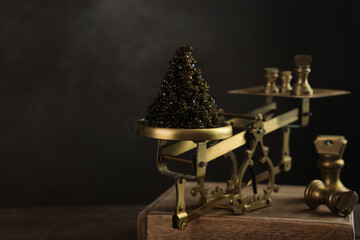 Black caviar. Black caviar is on the scales. Delicacy of sturgeon fish. Brass antique scales. A...
