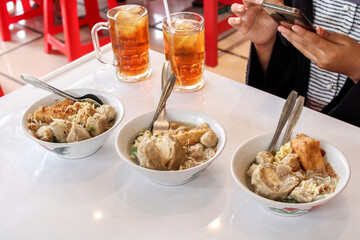 Women take pictures of meatballs before they are eaten