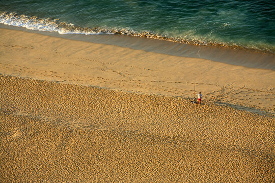A lone surfcasting fisherman tries his luck along the Pacific beach at Cabo San Lucas in Baja, Mexico.