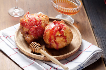 Close up of Italian Carnival Fritters with Alchermes - Carnival Strufoli typical Umbrian sweet dish for Carnival, on a wooden plate on rustic background.