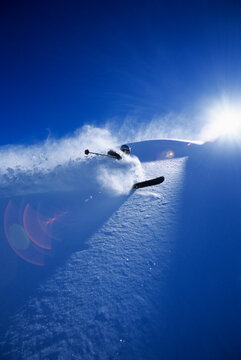 A skier makes turns through deep snow on a sunny, day in the Teton backcountry of Jackson Hole, Wyoming.