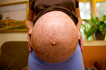 Pregnant woman with decorated belly.