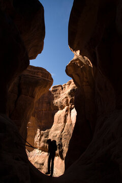 A silhouetted woman rappelling, Arches National Park, Moab, Utah.