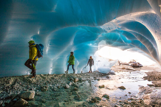 Adventure guide brings two female clients into a glacial cave.
