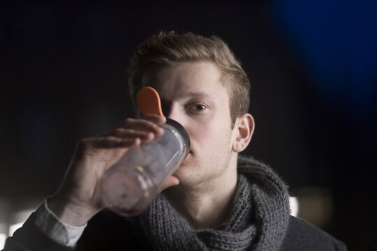 Young businessman drinking energy drink and working till late night, Freiburg im Breisgau, Baden-W&uuml;rttemberg, Germany