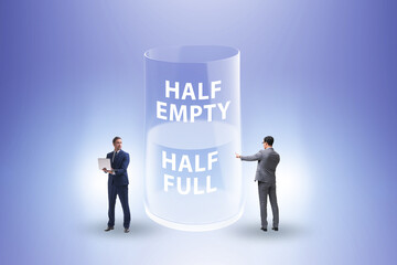 Businessman in half empty half full glass concept