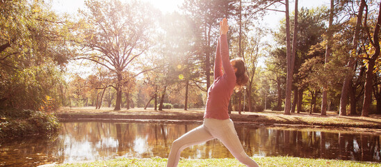 Young Woman Doing Yoga Exercise At Park in The Morning. 