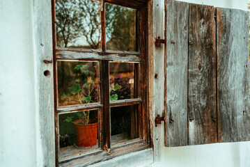 flowerpot in wooden old window in an old country house made of wood