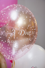 a bunch of pink birthday balloons, a drawing of a cute kitty on a latex balloon, the inscription 