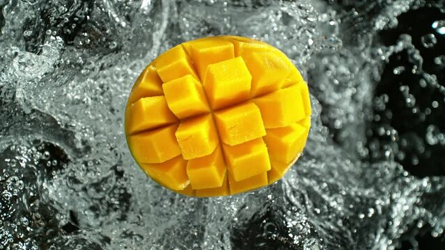 Super slow motion of mango with water splash. Filmed on high speed cinema camera, Isolated on black background. Speed ramp effect. 1000fps.