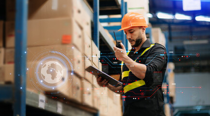  Storage worker in uniform Wearing Hard Hat Checks Stock and Inventory with Digital Tablet Computer...