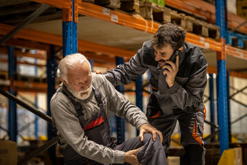 Warehouse situation, young worker comes to help senior worker, he got injured when carring heavy boxes