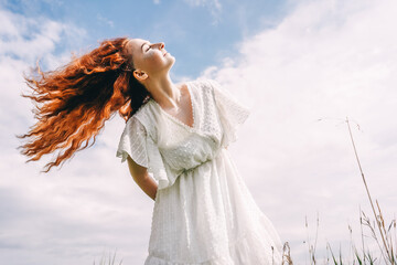 Happy woman with long hair on sky background.
