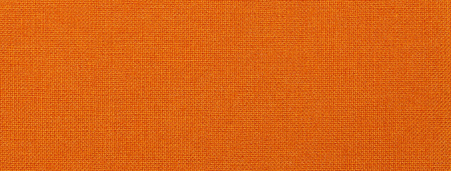 Texture of dark orange color background from textile material with wicker pattern. Vintage ginger fabric