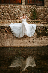 Dreamy portraits of beautiful bride on stone riverbank