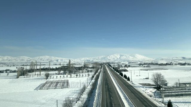 Aerial view of a freeway and distant mountains in winter