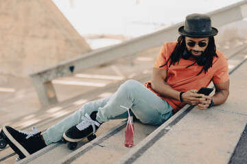  Black man enjoy outside. Modern man posing with roller skates