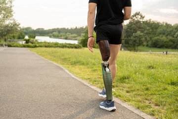 Details of a walk of a young man with prosthetic leg, young man with art and foot mechanic trains to walk at park, different posture