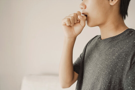 Close up of teen boy coughing from cold and flu,COPD, pneumonia, bronchitis, asthma, allergy, respiratory illness concept