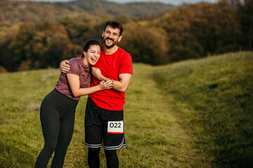 Fototapeta premium Loving embraced fit diverse couple exercise outdoors. They are wearing sports clothing, smiling, preparing, and supporting each other.
