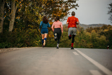 Rear view of a fitness sports people running lifestyle concept. Group of dedicated young people jogging together outdoors