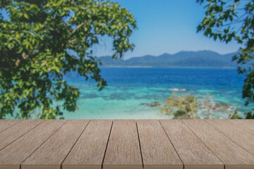 Wooden table with view of beautiful beach and sea with turquoise water.