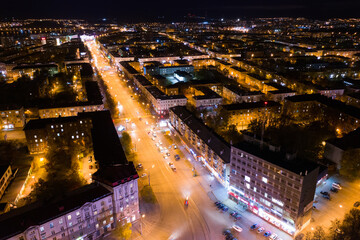Fototapeta na wymiar Top view of the night city in winter. Movement of cars on lighted streets and intersections