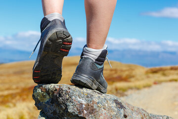 Hiking boot closeup on mountain rocks