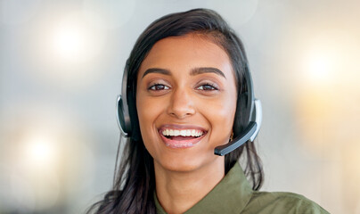 Happy, friendly and confident face of a call center agent smiling in her office with copy space....