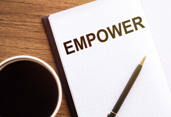 Empower word on paper notebook with cup of coffee, empowerment and leadership concept