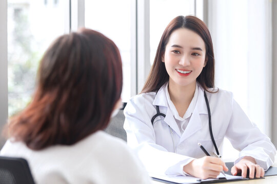 Asian professional doctor female who wears medical coat talks with woman patient to her patient elderly in examination room,healthcare concept in office of hospital.