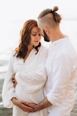 a guy with a girl in white clothes on the seashore