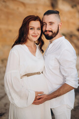 a guy with a girl in white clothes on the seashore
