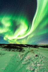 Fototapeta na wymiar imagen de una aurora boreal iluminando el cielo nocturno de Islandia con el paisaje nevado 