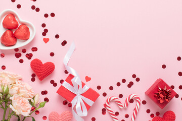 A mock-up of a Valentine's Day banner with gift boxes, knitted hearts and a bouquet of roses on a pink background.
