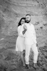 a guy with a girl in white clothes on the seashore