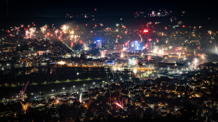 Fototapeta na wymiar Night View of City on New Year's Eve With Fireworks in Jena, Germany.