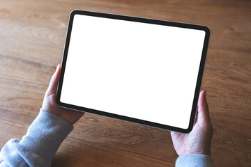 Top view mockup image of a woman holding digital tablet with blank white desktop screen