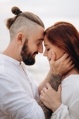 Fototapeta premium a guy with a girl in white clothes on the seashore