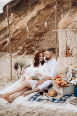 Fototapeta na wymiar pregnant girl and boyfriend on a picnic