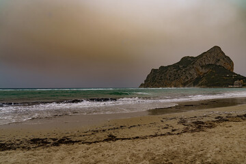 View of the coastal mountain Calp during sunset and during a sandstorm