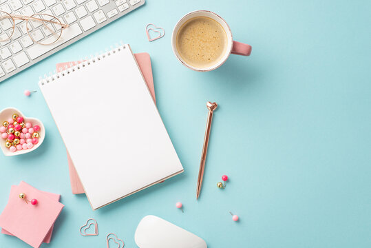 Valentine's Day concept. Top view photo of keyboard diary pen sticky note paper heart shaped saucer pushpins glasses cup of coffee and computer mouse on isolated pastel blue background with copyspace