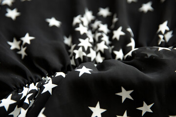 Black folded fabric with white stars pattern as texture background