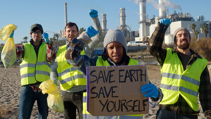 Group of young multiethnic volunteers collecting garbage in nature protesting pollution and climate...
