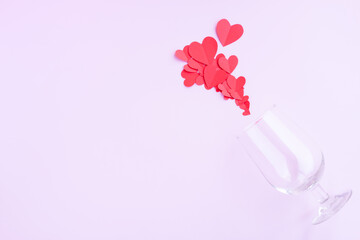 Wine glass with  Red paper hearts shape on pink background, Happy Valentine's day